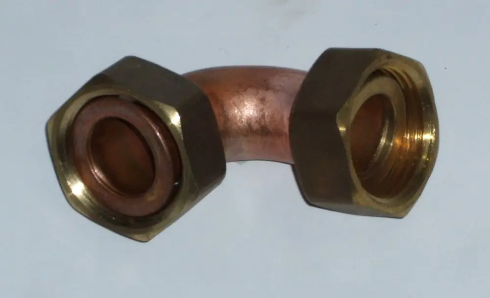 Rücklaufrohr mit gewinkeltem Design, aus Kupfer und Messing, geeignet für Daikin Rotex GW T-Modelle bis Baujahr 2019, ohne sichtbare Beschriftungen oder Maße.